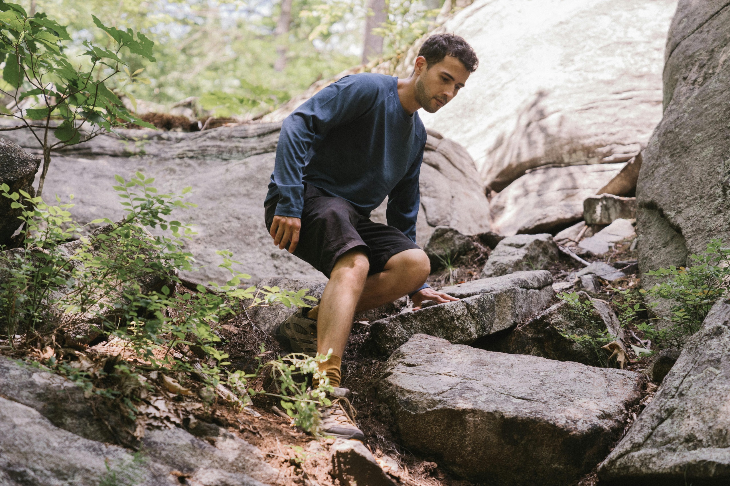 Hiker experiencing knee pain walking downhill on a forest trail in Malaysia
